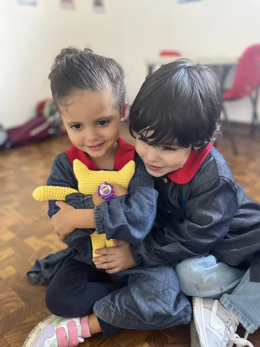Dos niños con el uniforme de Piruli abrazados, sonriendo